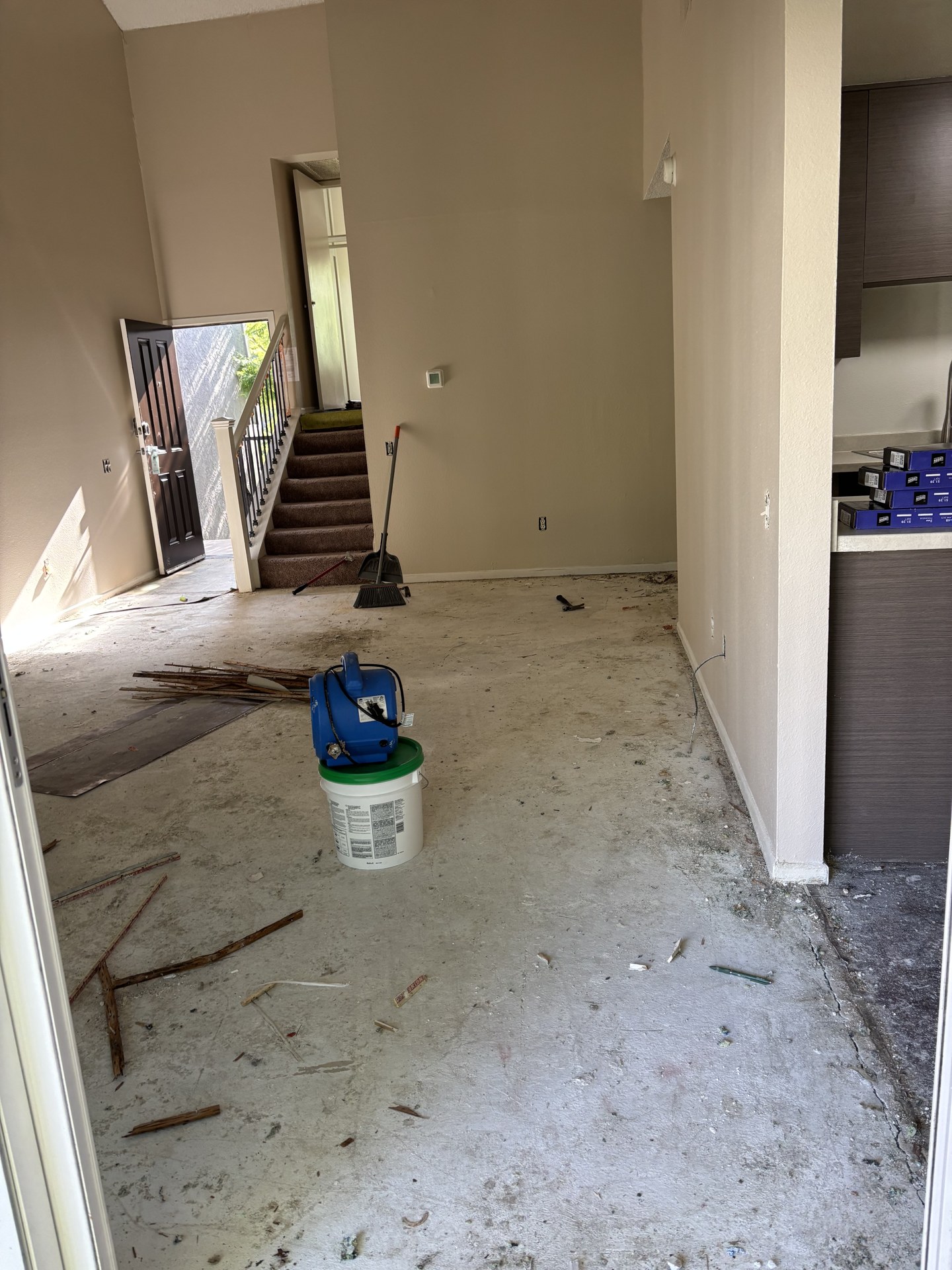 Exposed subfloor beside the staircase before plank flooring installation